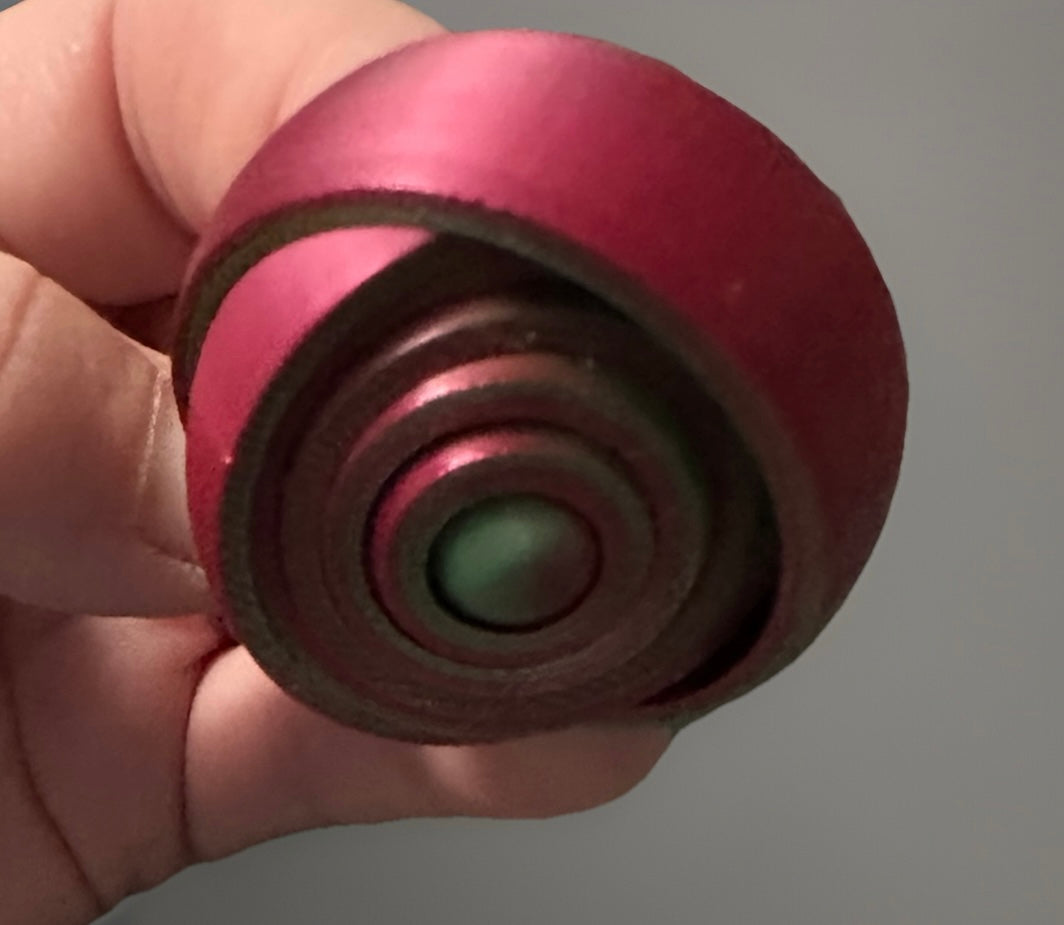 A red 3D gyro fidget spinner with concentric circular design from Reed’s Rubber Ducks and Sensory Shop