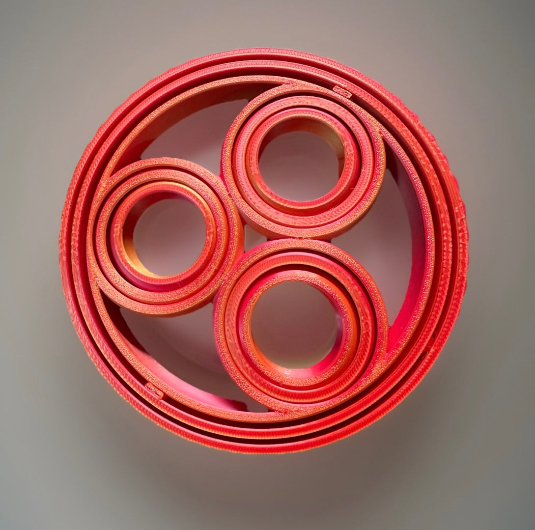 Red 3D rotating fidget rings in concentric circular design for sensory and stress relief