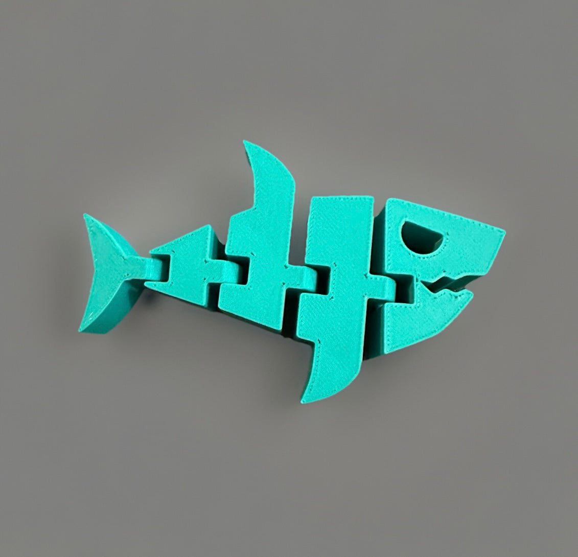 Turquoise articulated shark fidget toy with segmented movable parts from Reed’s Rubber Ducks and Sensory Shop