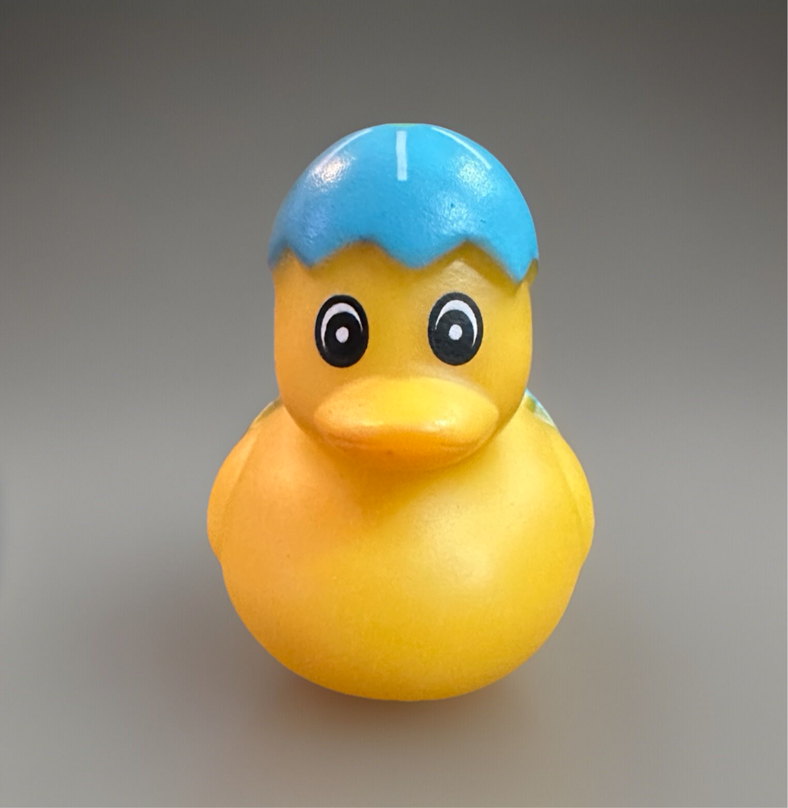 Colorful blue Easter egg rubber duck with a cheerful expression and blue hat for festive celebrations