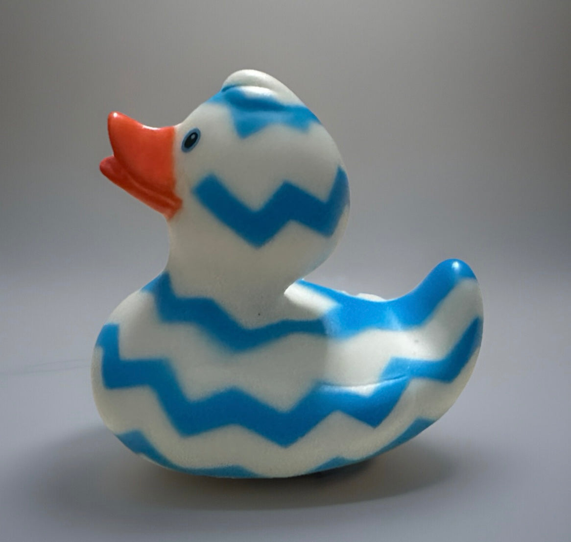 Blue Zig Zag Rubber Duck with orange beak and white body featuring blue zigzag stripes