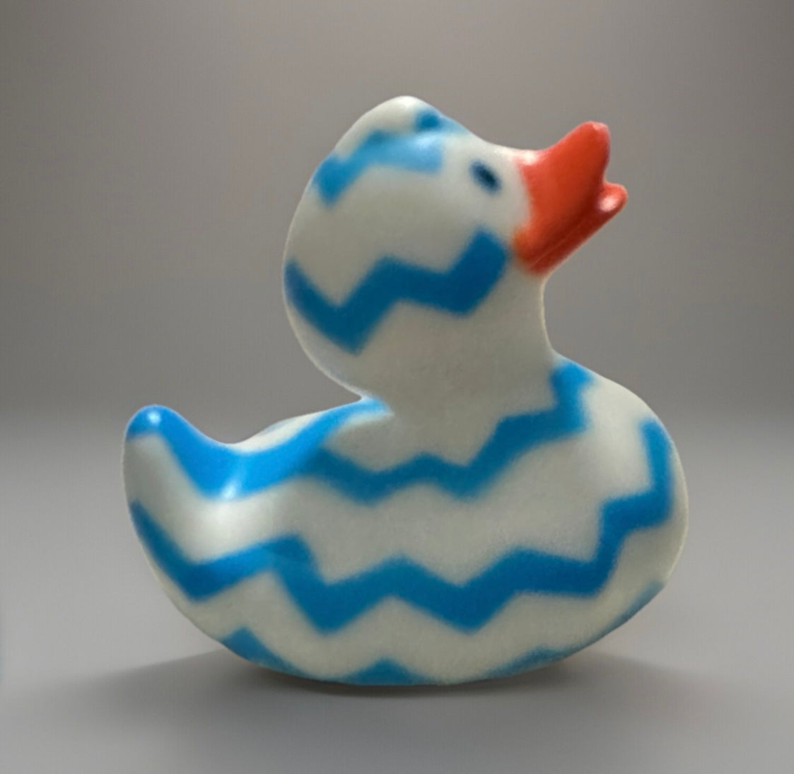 Blue Zig Zag Rubber Duck with bright orange beak and white body with blue zigzag patterns