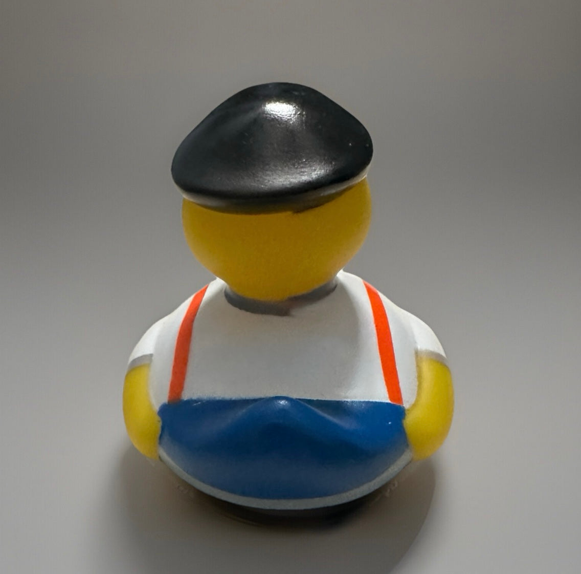 Bow tie rubber duck wearing black beret white shirt blue apron and red suspenders