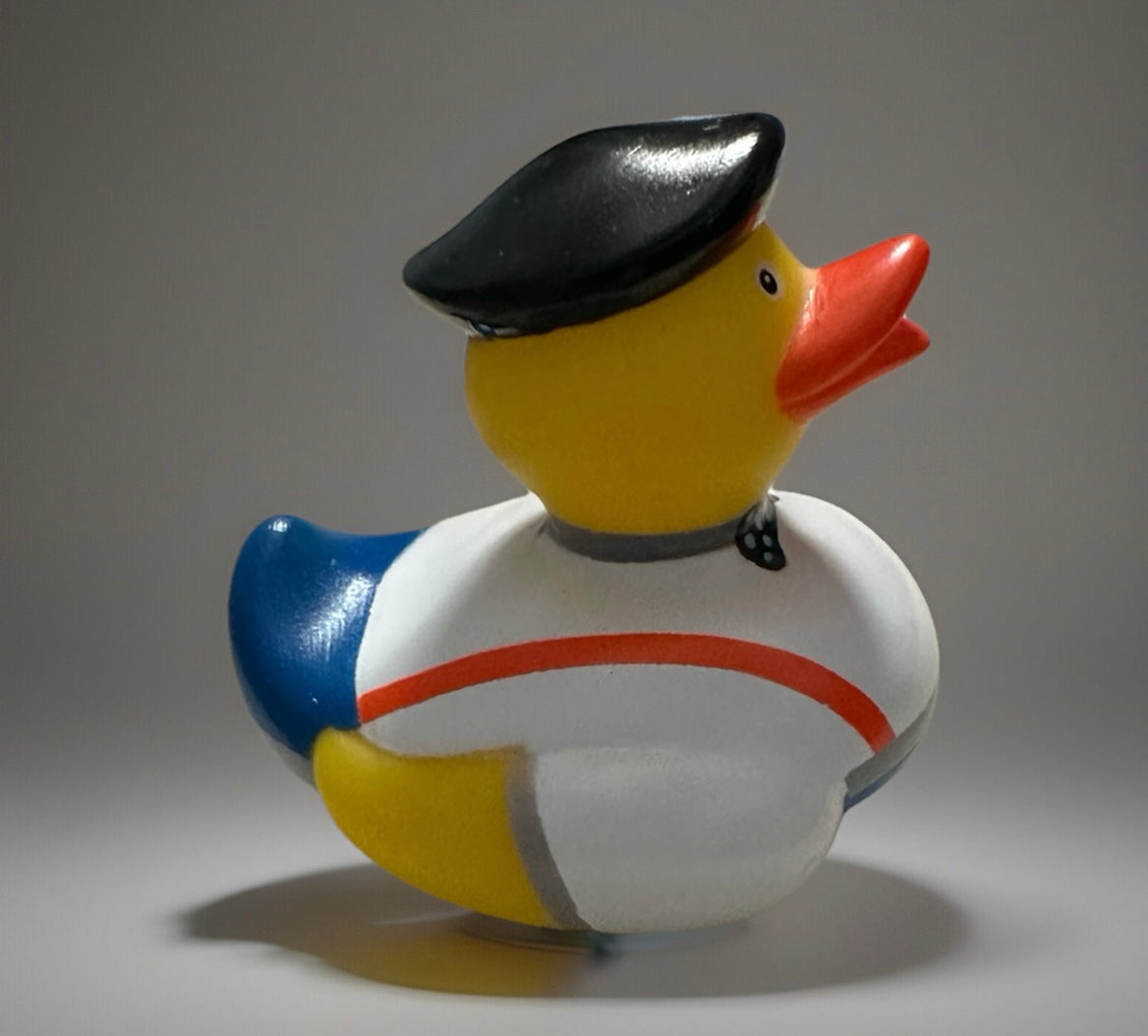 Bow tie rubber duck wearing a black beret and white outfit with red stripe from Reed’s Rubber Ducks and Sensory Shop