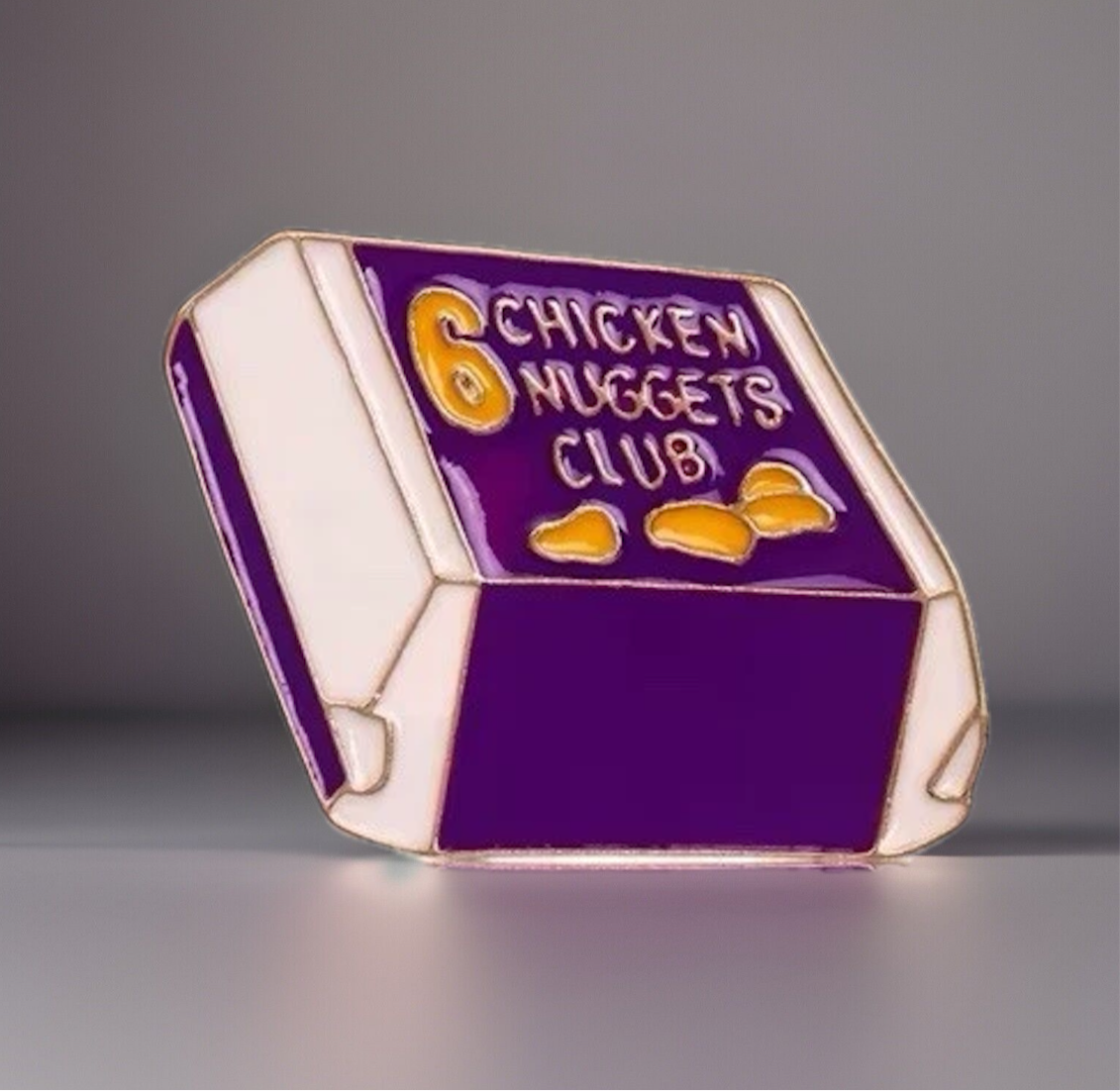 Purple and white chicken nuggets box enamel pin with 6 nuggets and chicken nuggets club pin text