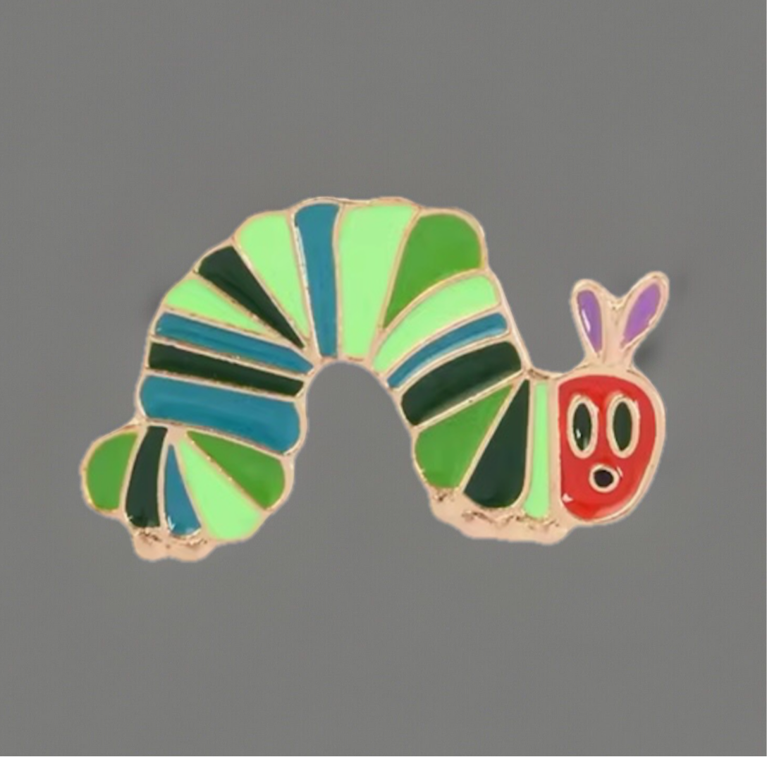 Colorful striped caterpillar enamel pins with green, blue, and red segments from Reed’s Rubber Ducks and Sensory Shop