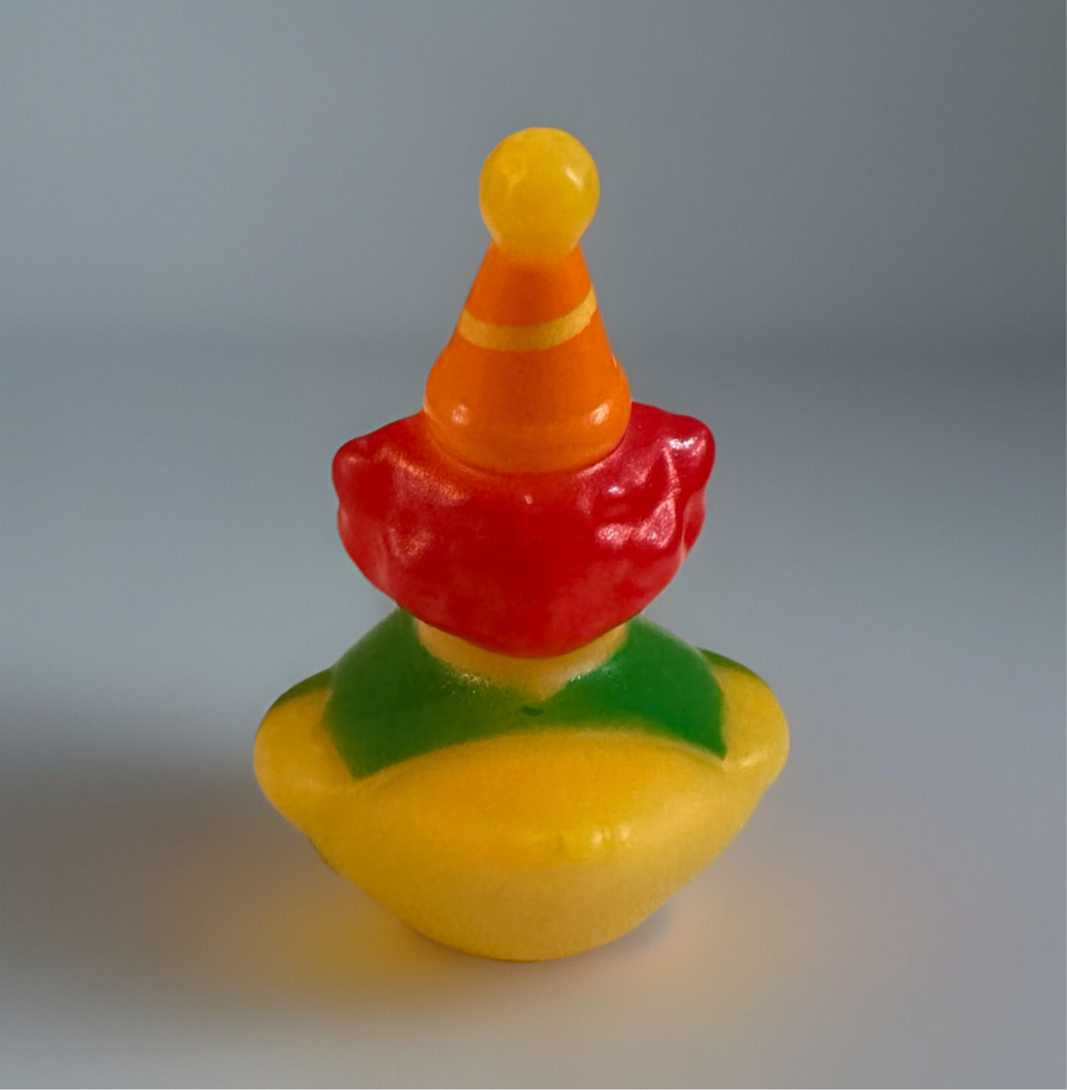 Colorful clown rubber duck with red hair, orange party hat, and green collar on yellow body