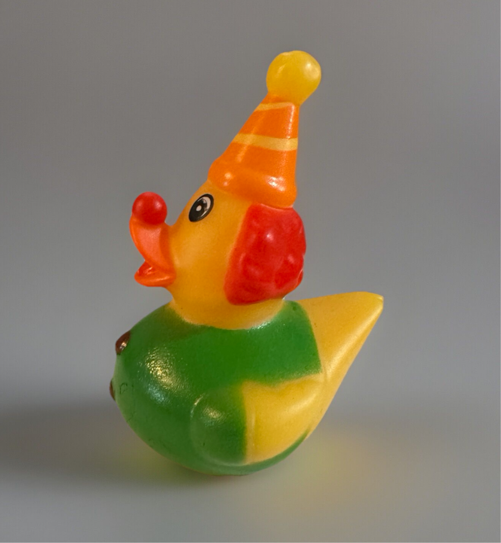 Colorful clown rubber duck with red nose, orange hat, and green outfit from Reeds Rubber Ducks and Sensory Shop