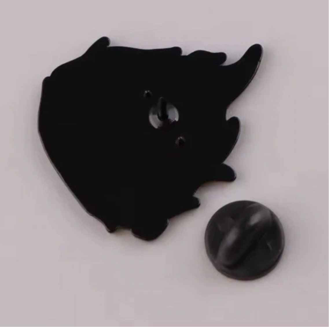 Back side view of a cute fire anime pins with black metal pin and clasp from Reed’s Rubber Ducks and Sensory Shop