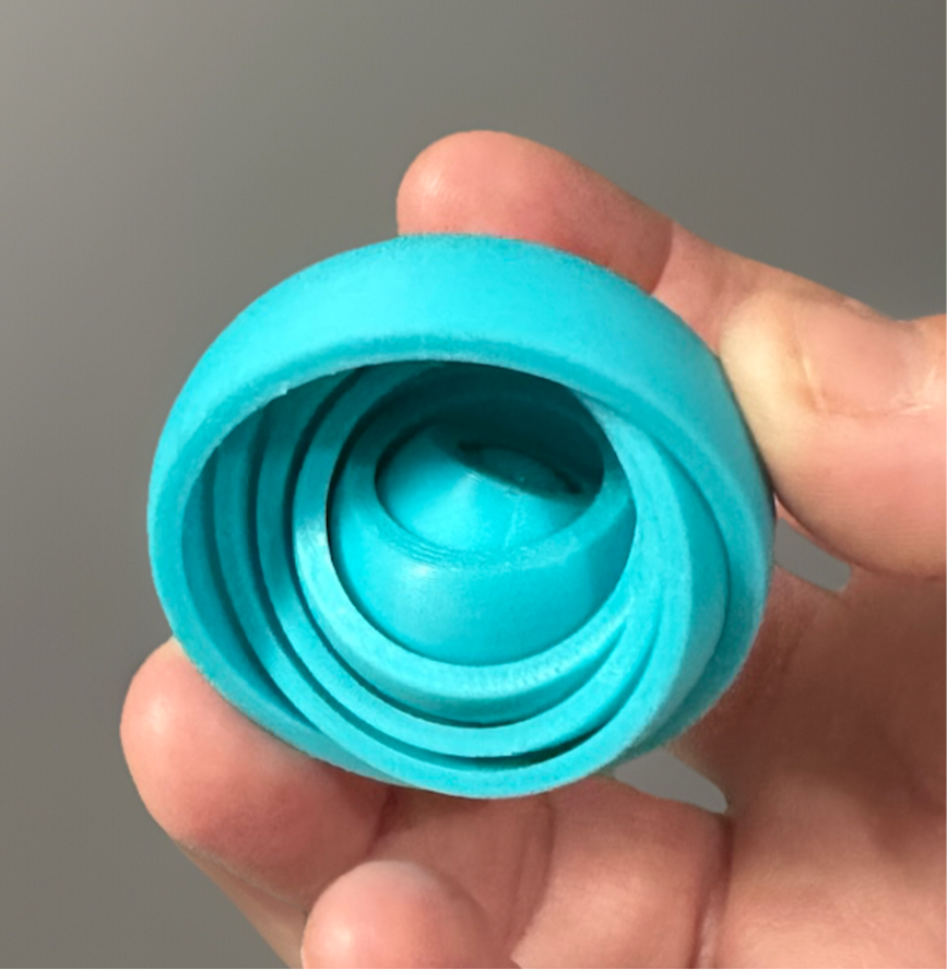 Hand holding a blue 3D gyro finger spinner from Reed’s Rubber Ducks and Sensory Shop