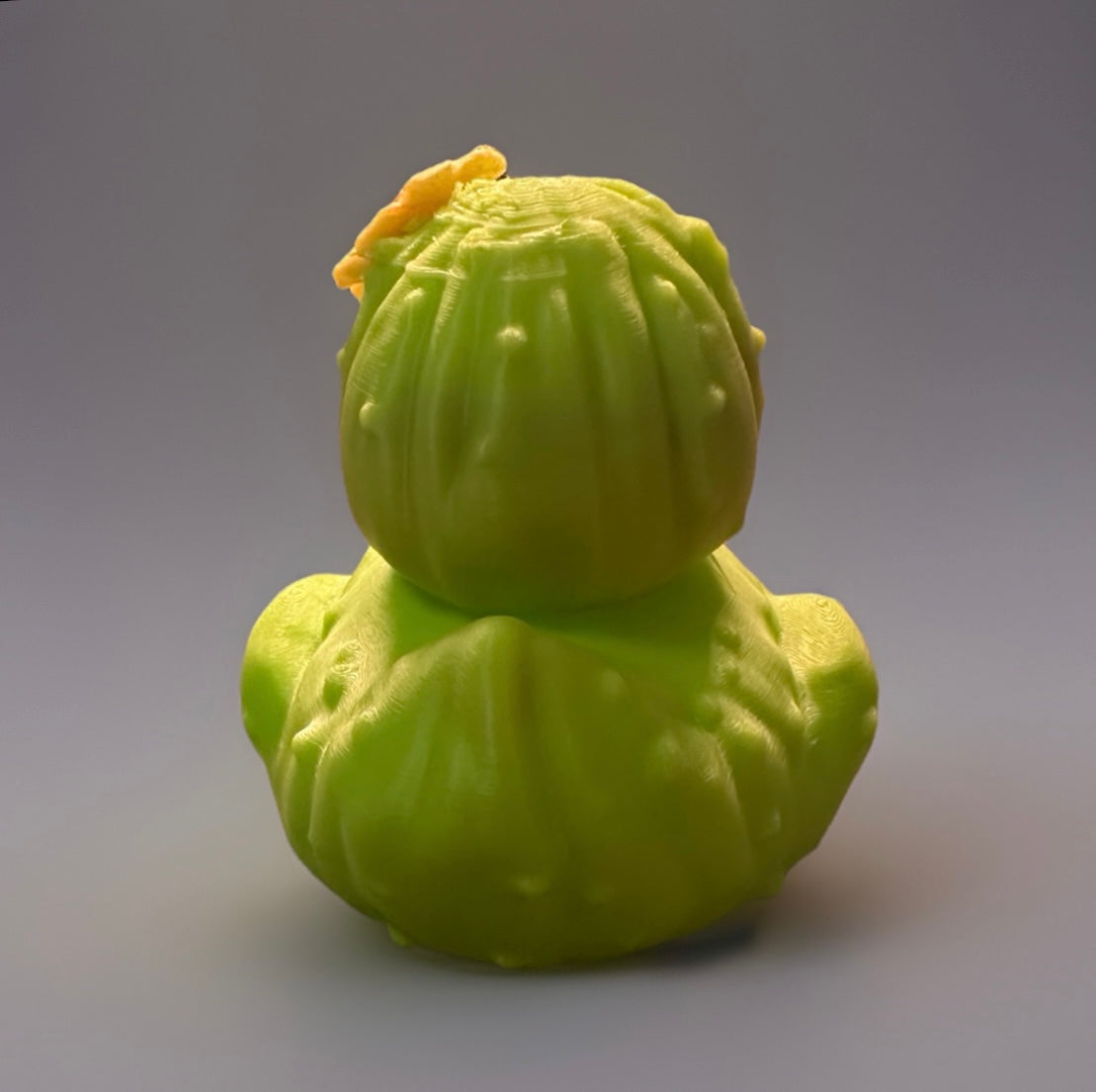 3D printed cactus duck in bright green with detailed cactus texture and small yellow flower on top