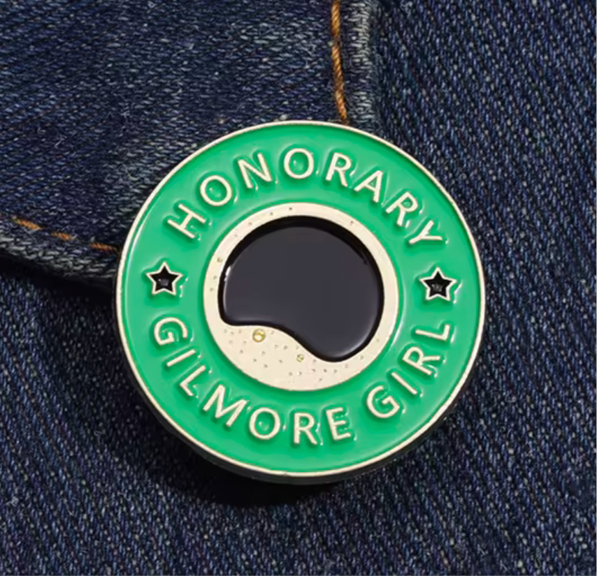 Gilmore Girls coffee pin featuring a green circular design with text and a coffee cup illustration