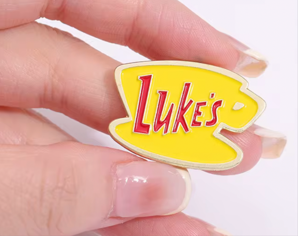 Gilmore Girls Lukes Enamel Lapel Pin featuring a cheerful yellow coffee cup design