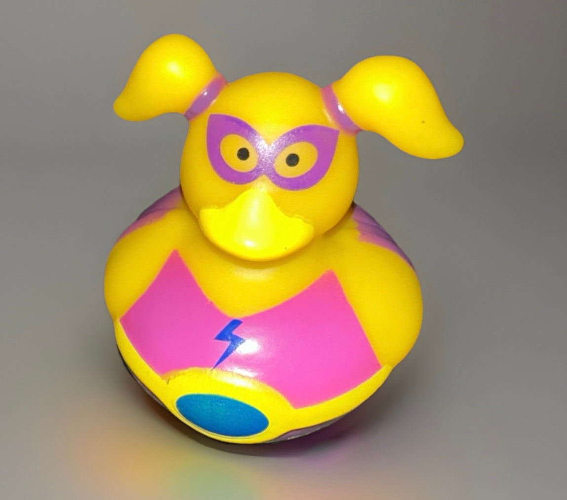 Girl superhero rubber duck with yellow body, pink mask, and lightning bolt emblem from Reed’s Rubber Ducks and Sensory Shop