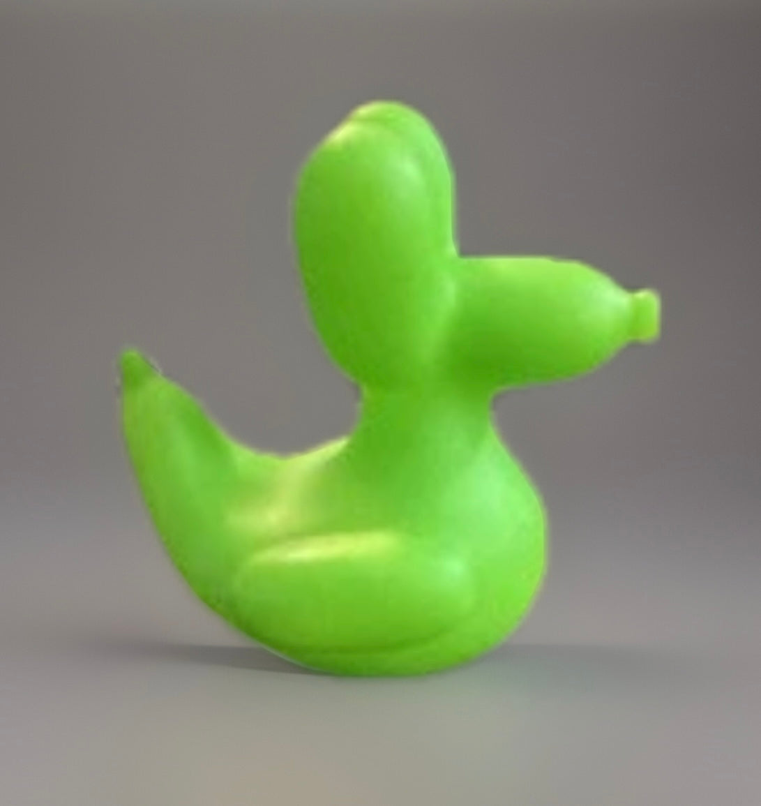 Green balloon animal rubber duck shaped like a duck, made of smooth bright green material