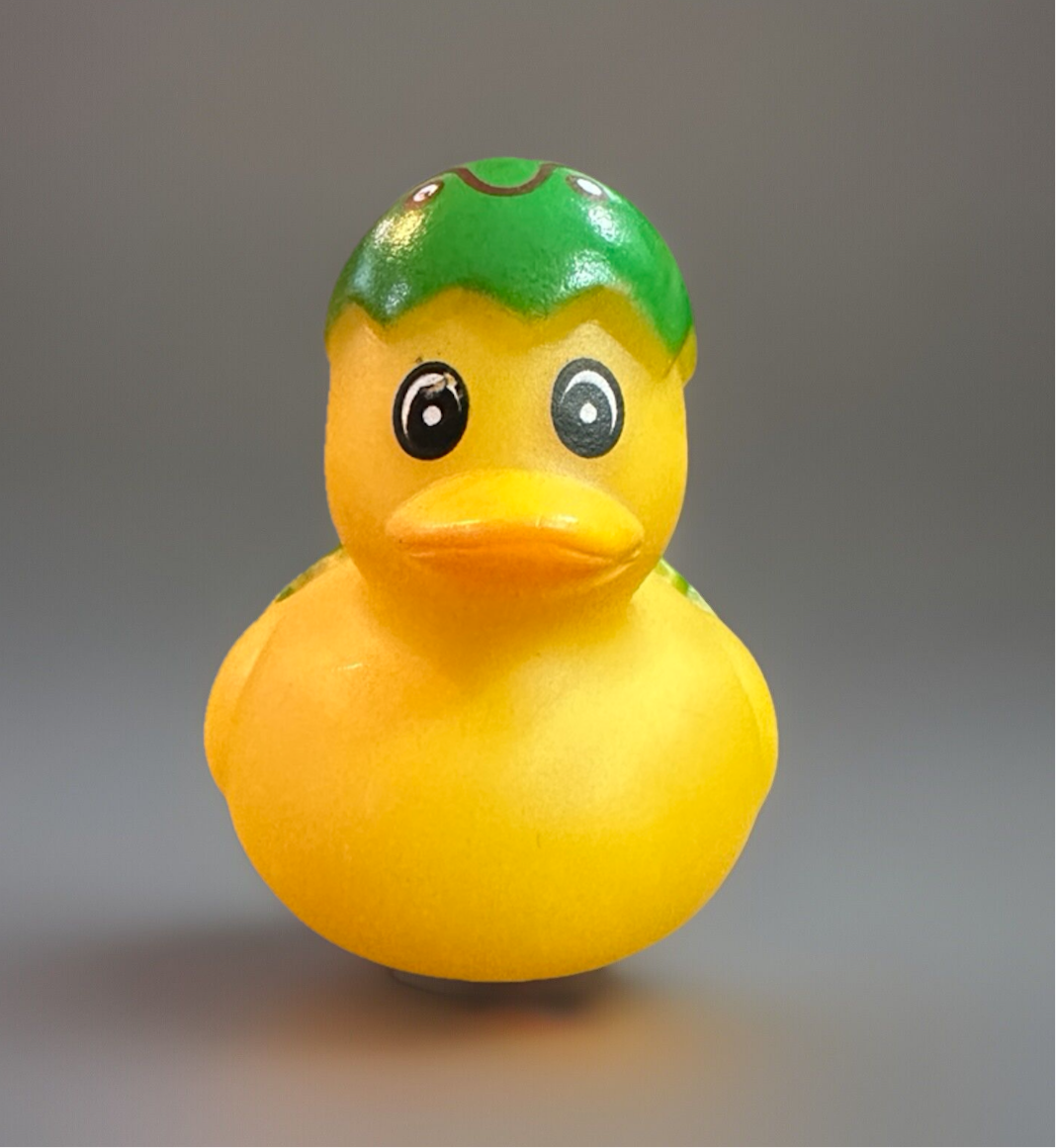 Green Easter egg rubber duck with a yellow body and a cheerful expression for sensory play