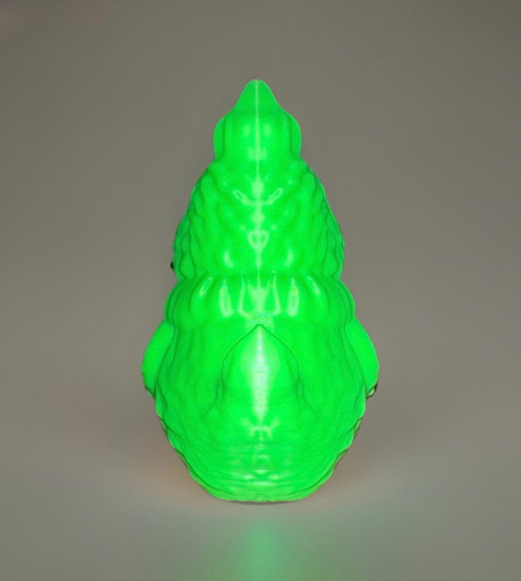 Glowing green Grinch theme duck from Reed’s Rubber Ducks and Sensory Shop bright in dark background