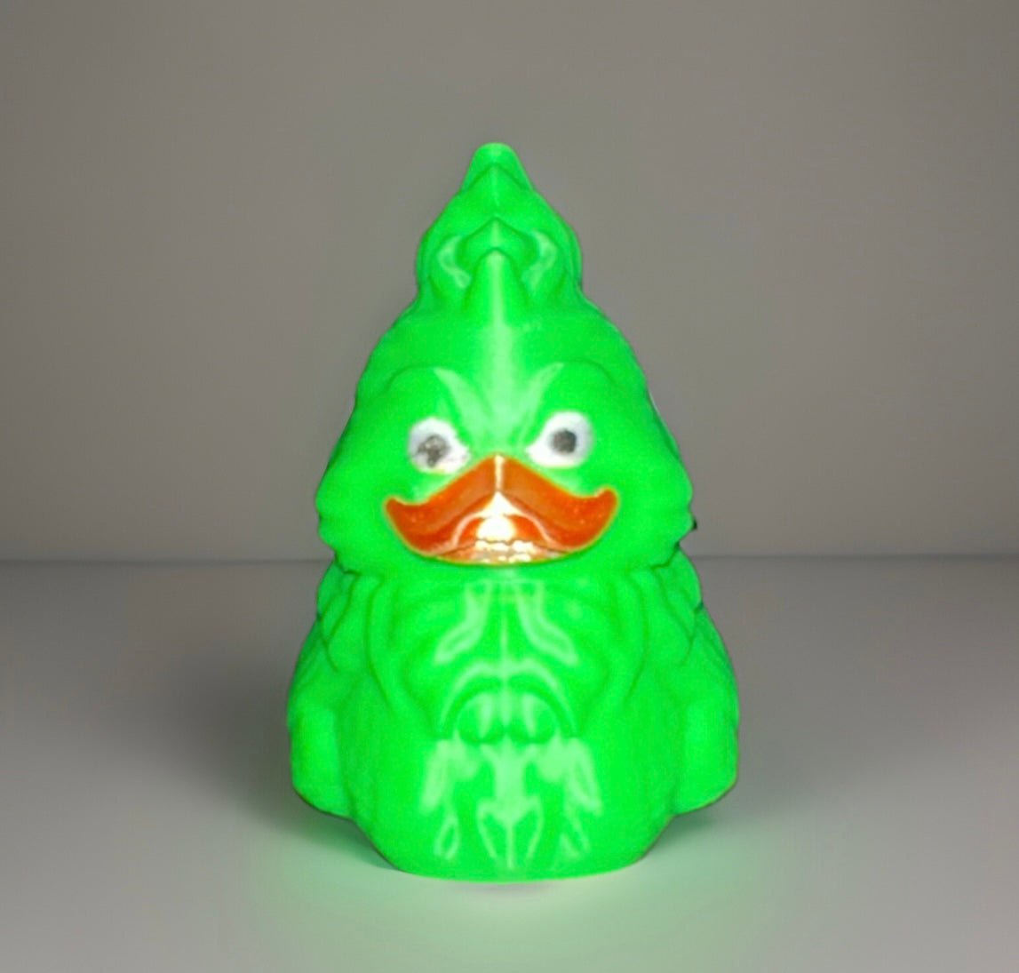 Bright green Grinch theme duck with orange beak and detailed facial features from Reed’s Rubber Ducks and Sensory Shop