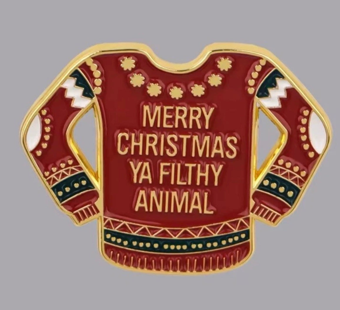 Home Alone enamel pin featuring a red Christmas sweater with Merry Christmas Ya Filthy Animal text