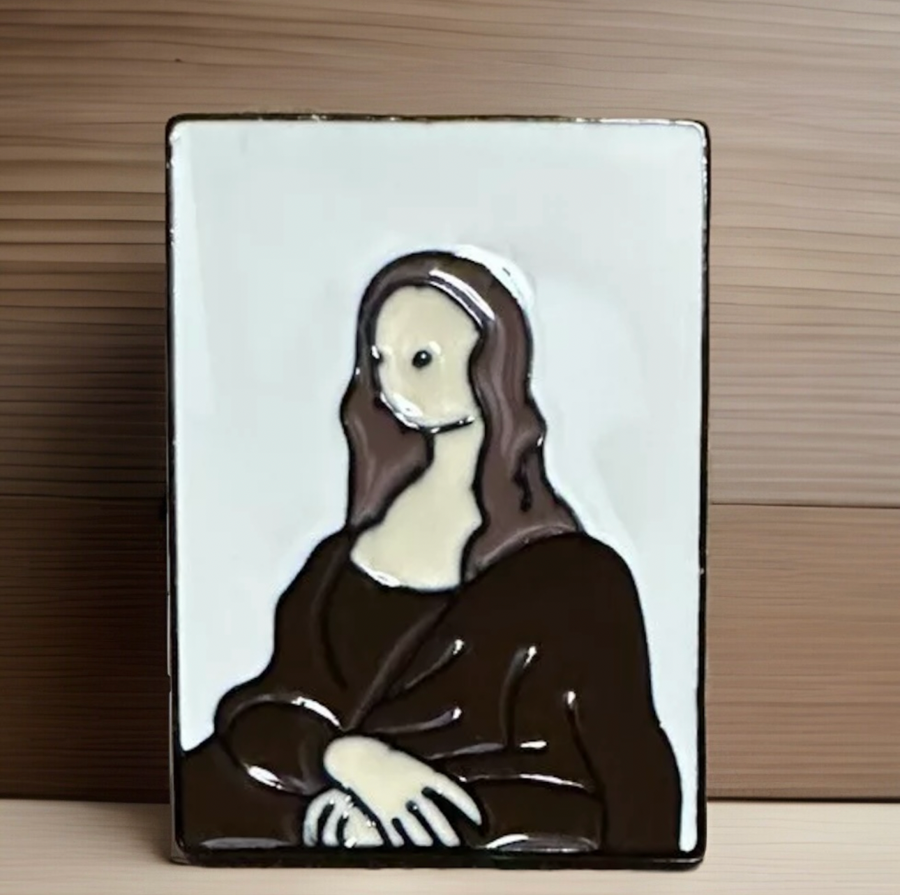 Leonardo Da Vinci lapel pin featuring a stylized depiction of the Mona Lisa with brown and cream colors