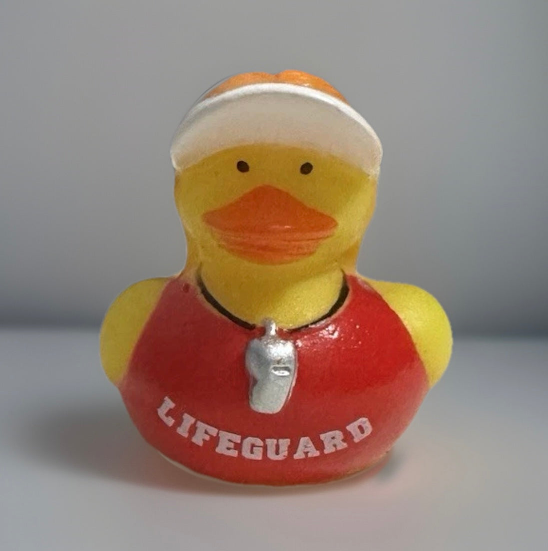 Lifeguard rubber duck wearing red lifeguard vest and whistle from Reeds Rubber Ducks and Sensory Shop