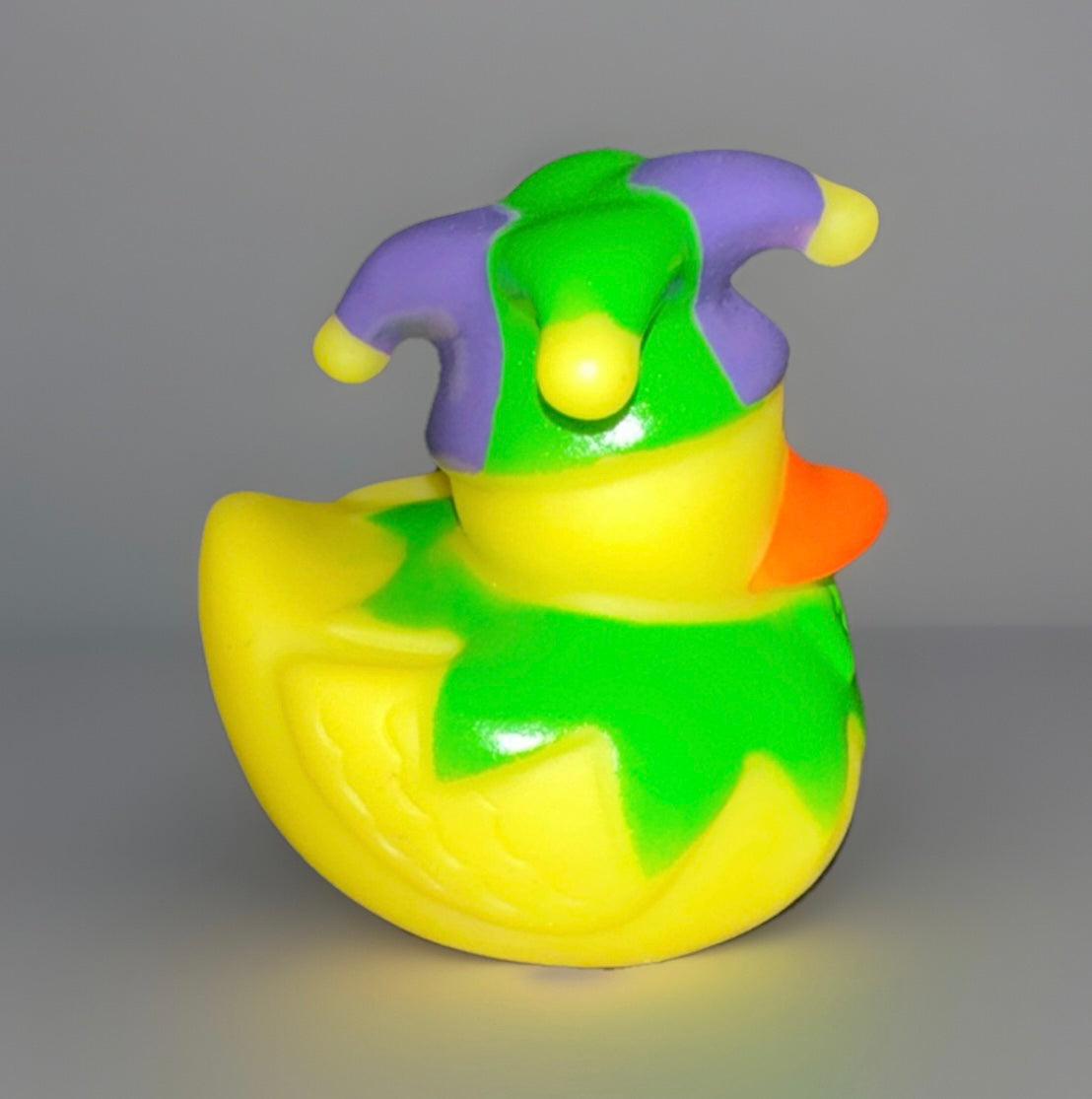 Mardi Gras rubber duck wearing purple and green jester hat in vibrant yellow and green colors