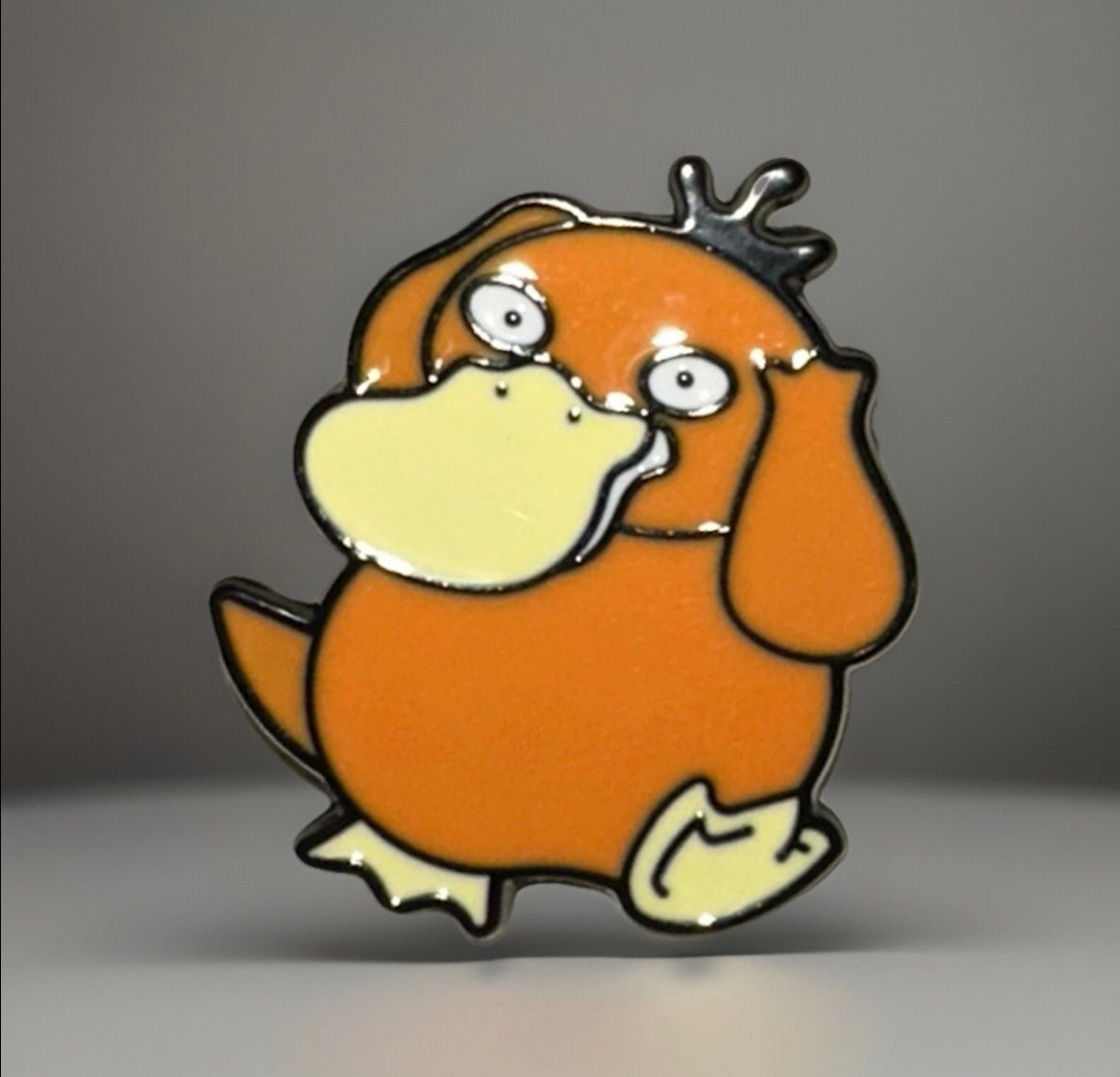 Pokemon Psyduck lapel pin featuring an orange and cream enamel design with black outline
