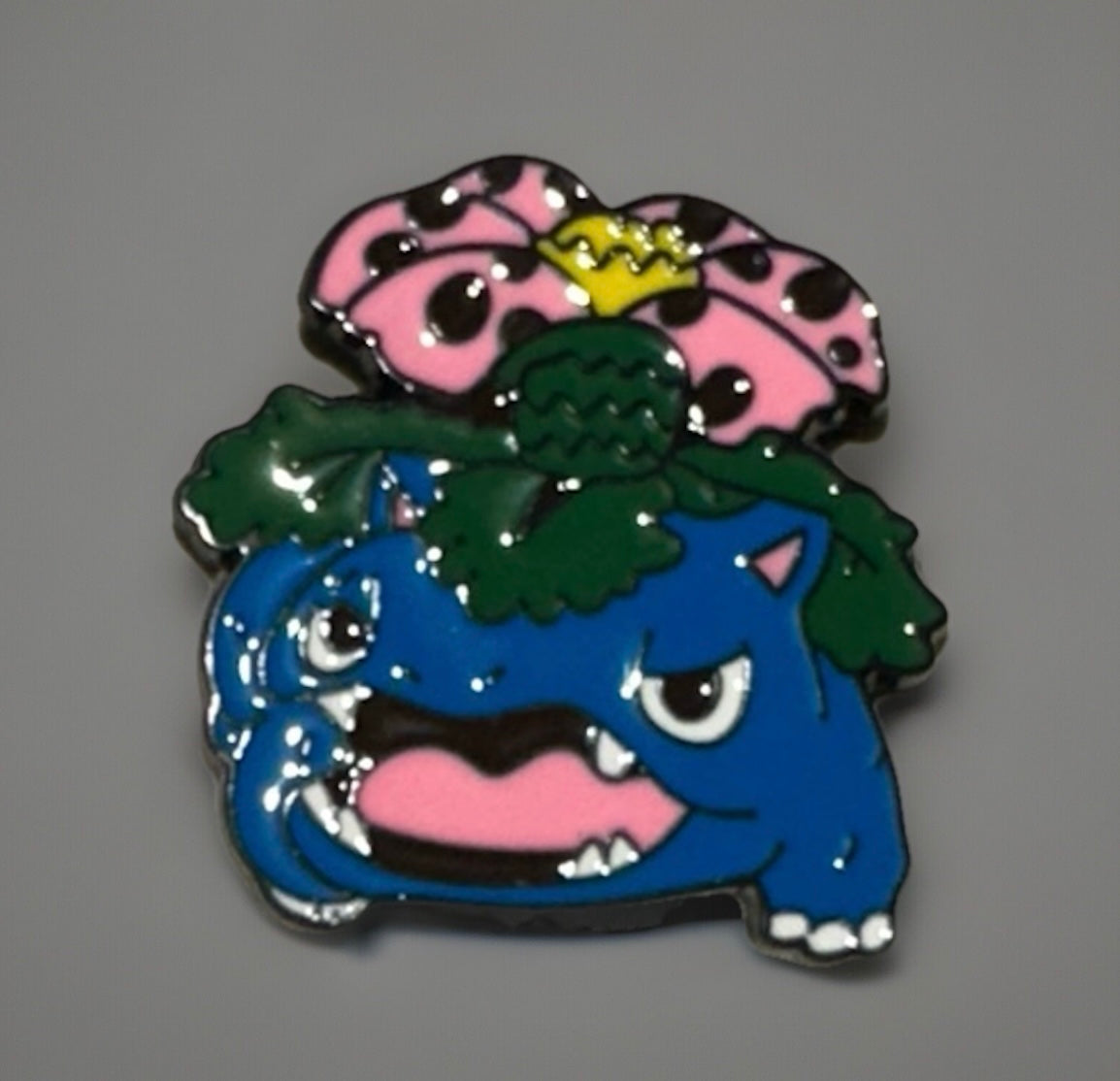 Pokemon Venusaur enamel pin featuring vibrant blue and pink design with green leaves and a yellow crown