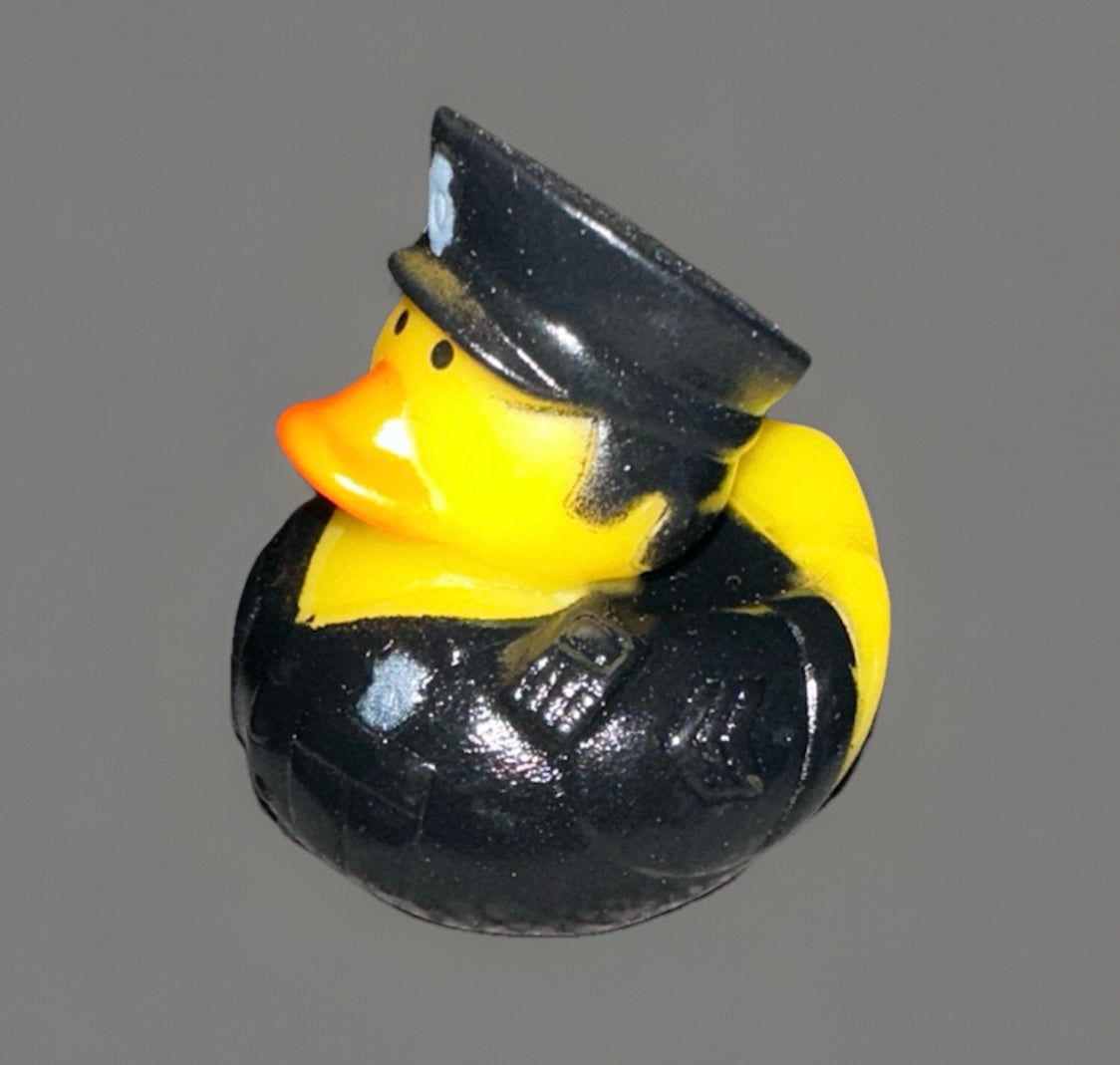 Yellow police rubber duck wearing a black police uniform and hat with orange beak