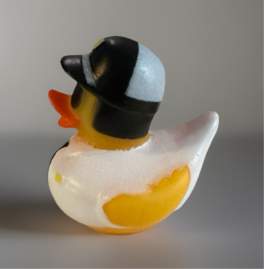 Police rubber duck wearing a black helmet with white and yellow details from Reed’s Rubber Ducks and Sensory Shop