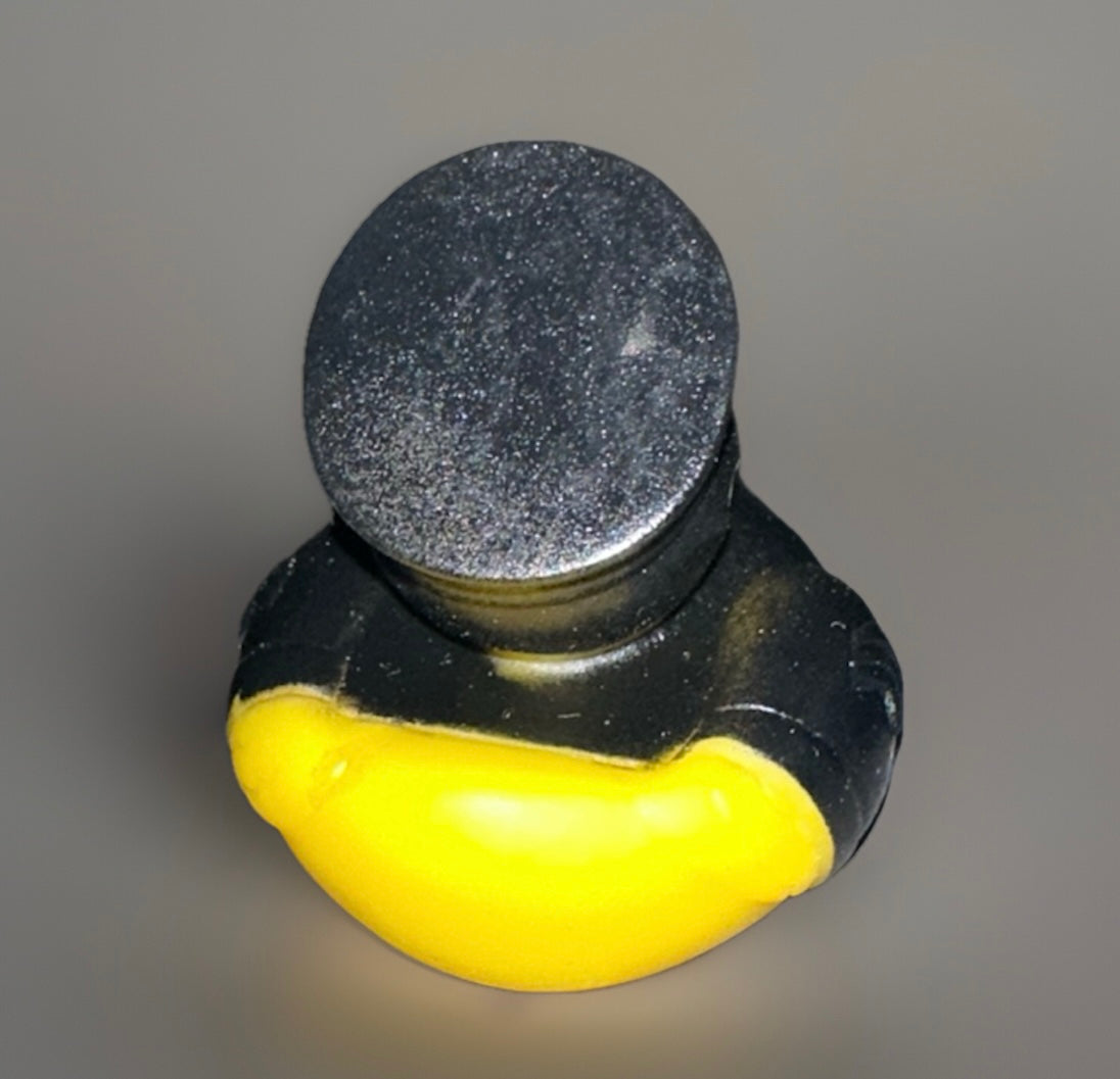 Top view of a police rubber duck with a black hat and yellow body from Reed’s Rubber Ducks and Sensory Shop