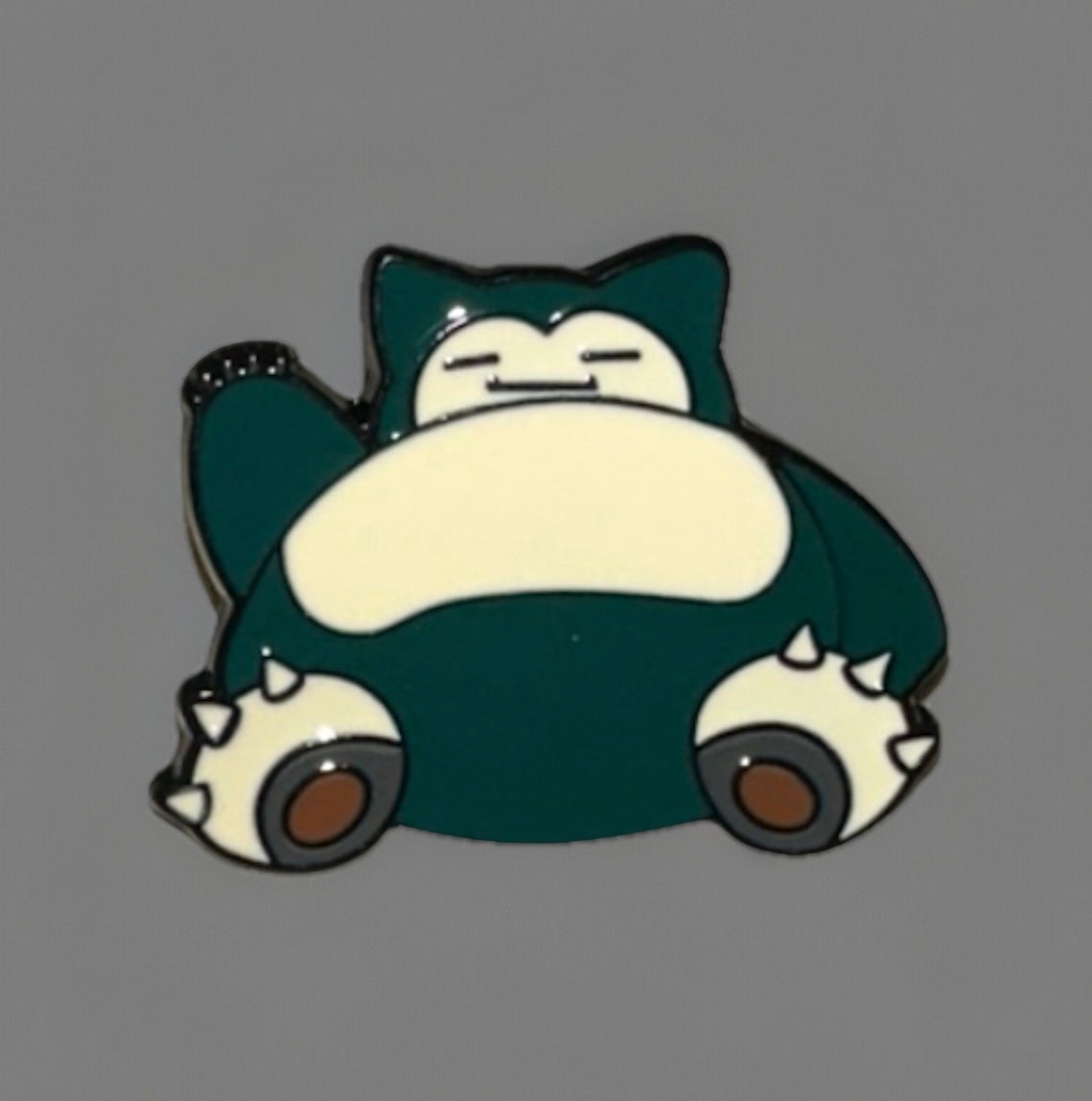 Snorlax enamel pin featuring the sleeping Pokemon character in dark green and cream colors