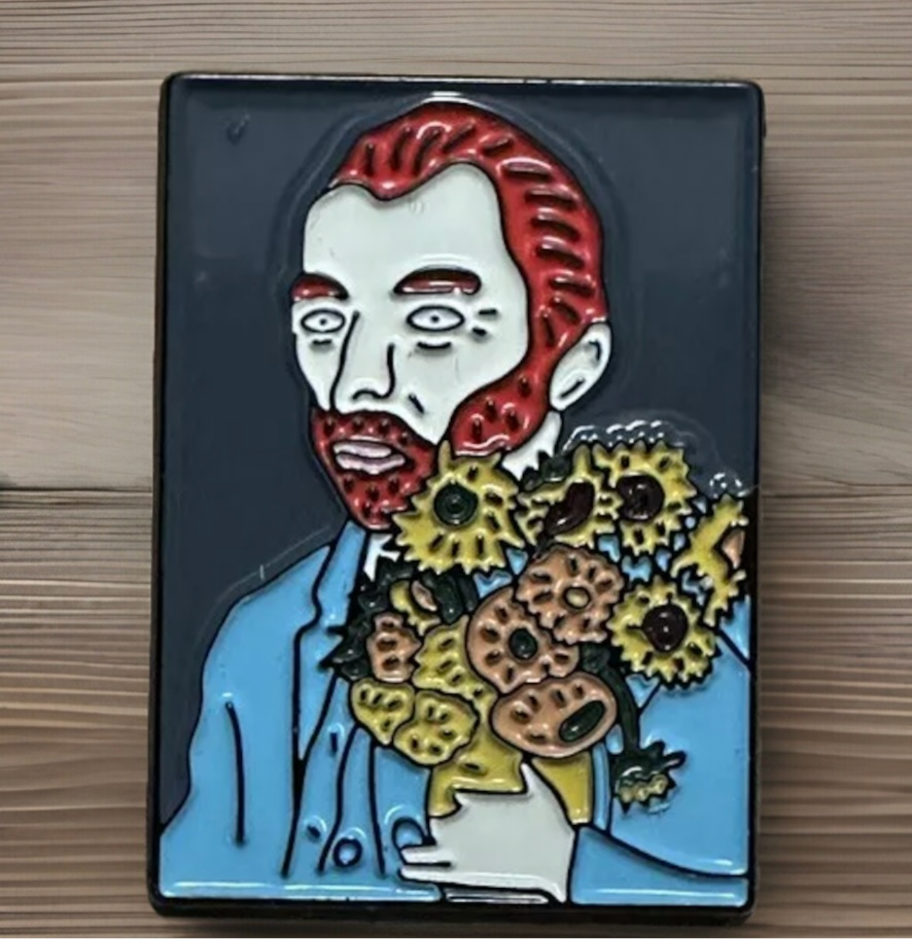 Van Gogh enamel pin featuring a red-haired man holding a bouquet of sunflowers on a black background
