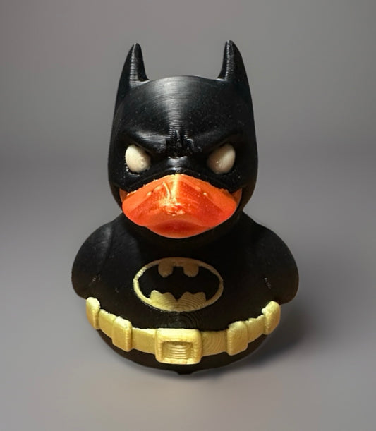 3D printed Batman duck in black with orange beak and yellow utility belt by Reed’s Rubber Ducks