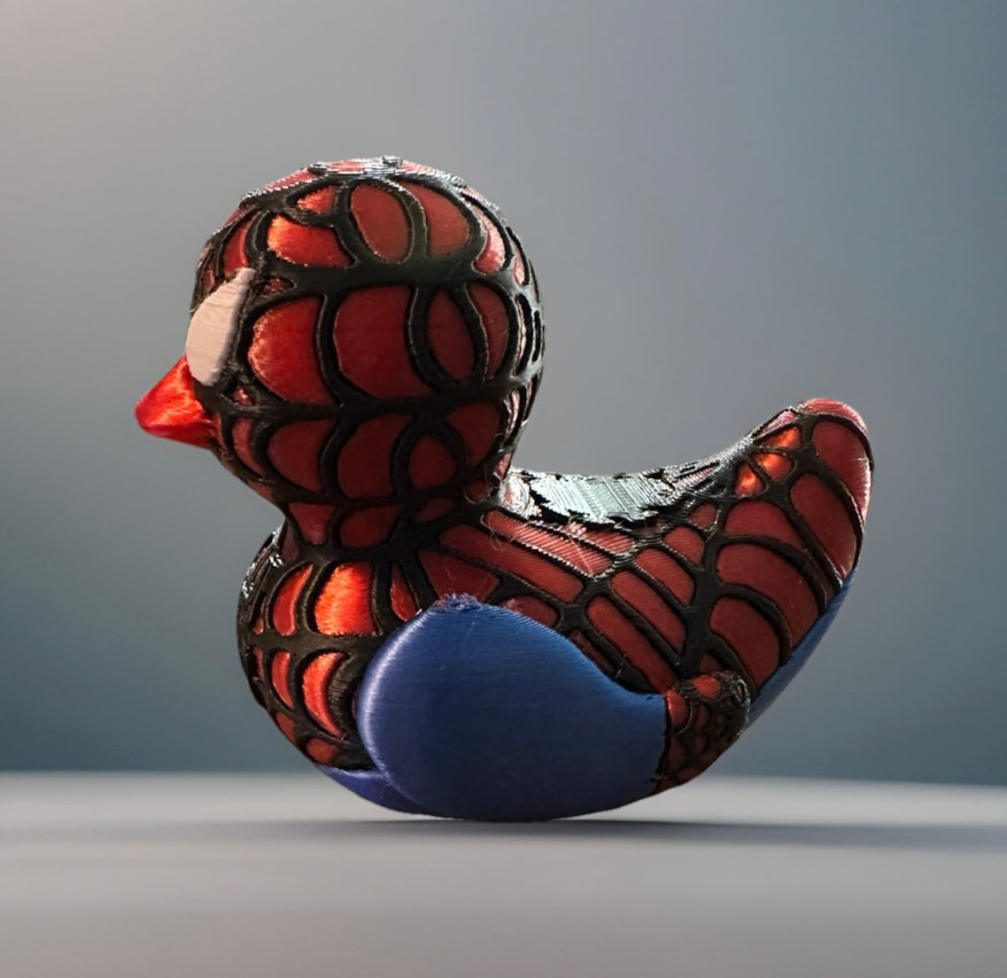 3D printed Spider-Man duck with red and black web pattern and blue accents from Reed’s Rubber Ducks and Sensory Shop