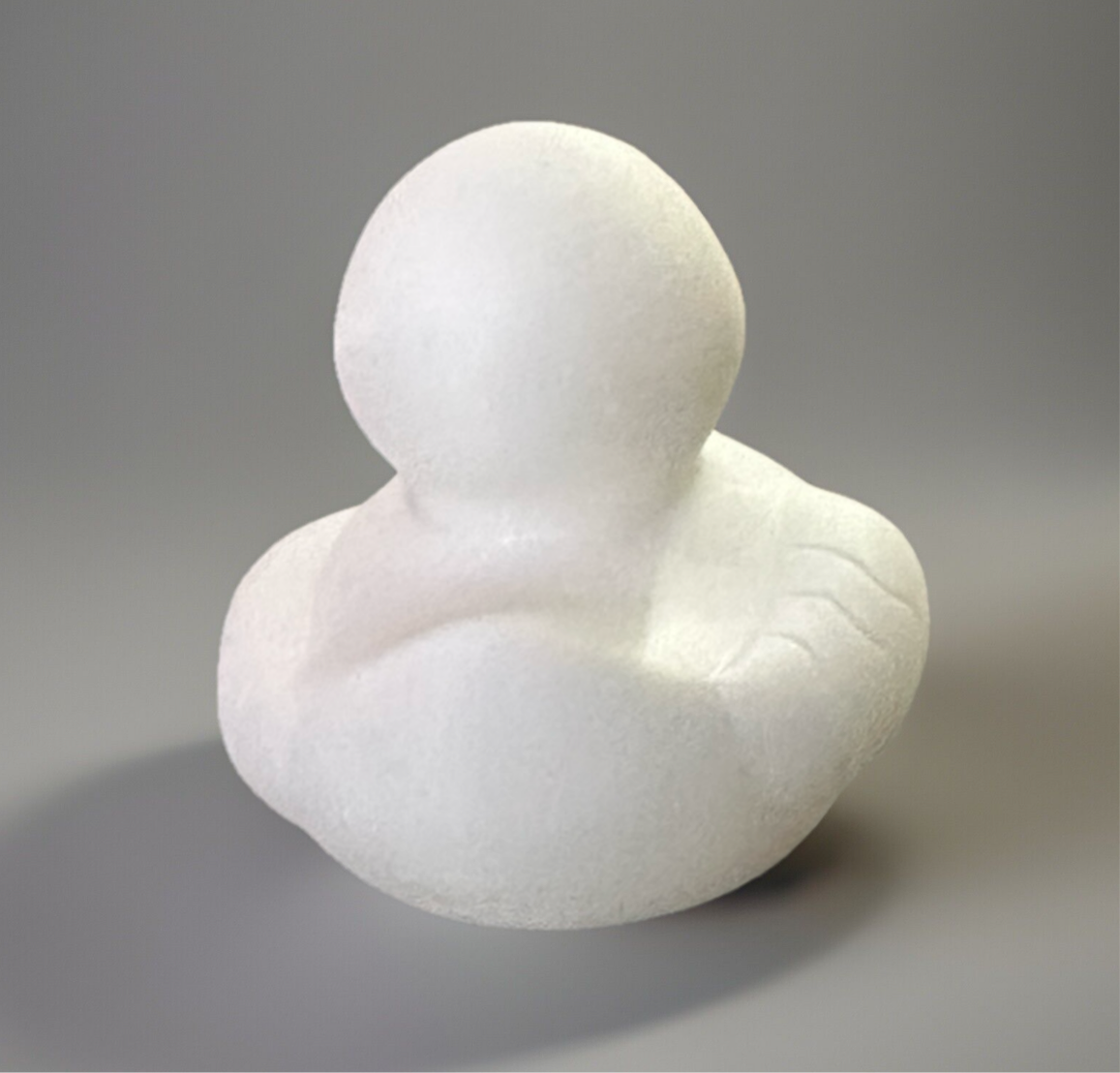 Plain white unpainted Autism awareness rubber duck made of smooth material on gray background