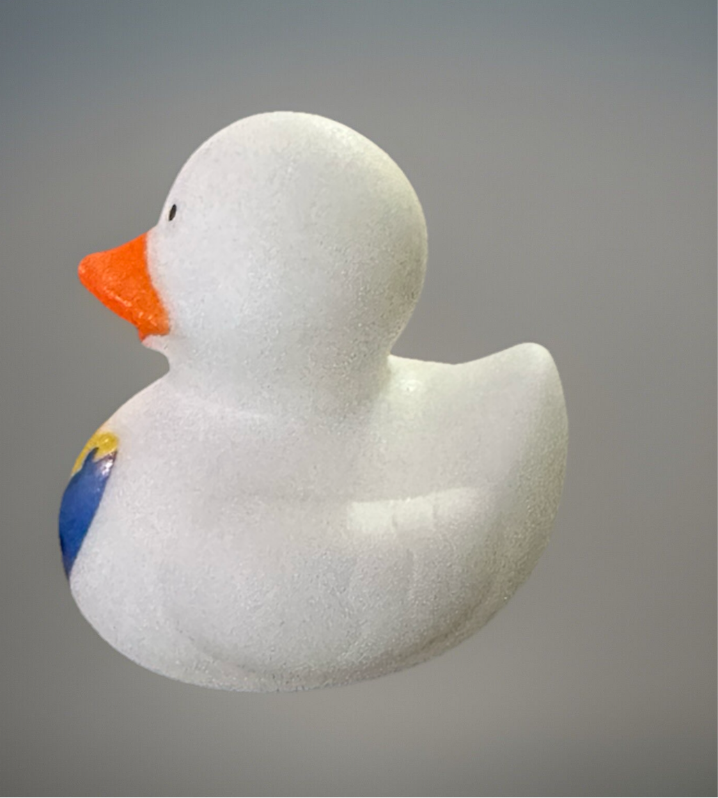 White Autism awareness rubber duck with orange beak and colorful puzzle piece design on chest