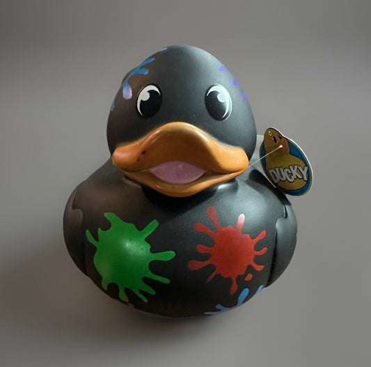 Black paint splatter rubber duck with colorful splashes and orange beak from Reeds Rubber Ducks and Sensory Shop