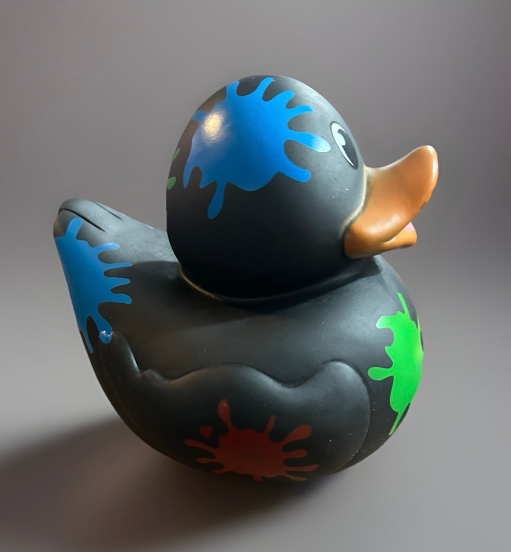 Black paint splatter rubber duck with colorful blue, green, and red paint splashes from Reed’s Rubber Ducks and Sensory Shop