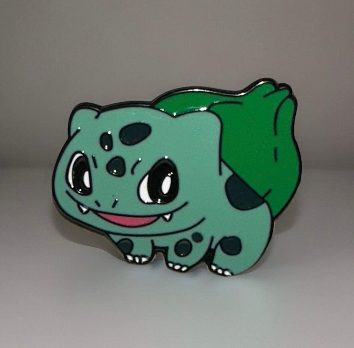 Bulbasaur enamel pin featuring a cute green Pokémon character with a leaf on its back