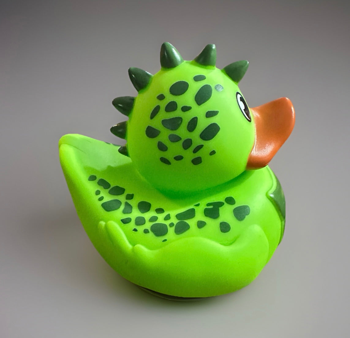 Green dinosaur rubber duck with dark green spots and spikes from Reed’s Rubber Ducks and Sensory Shop