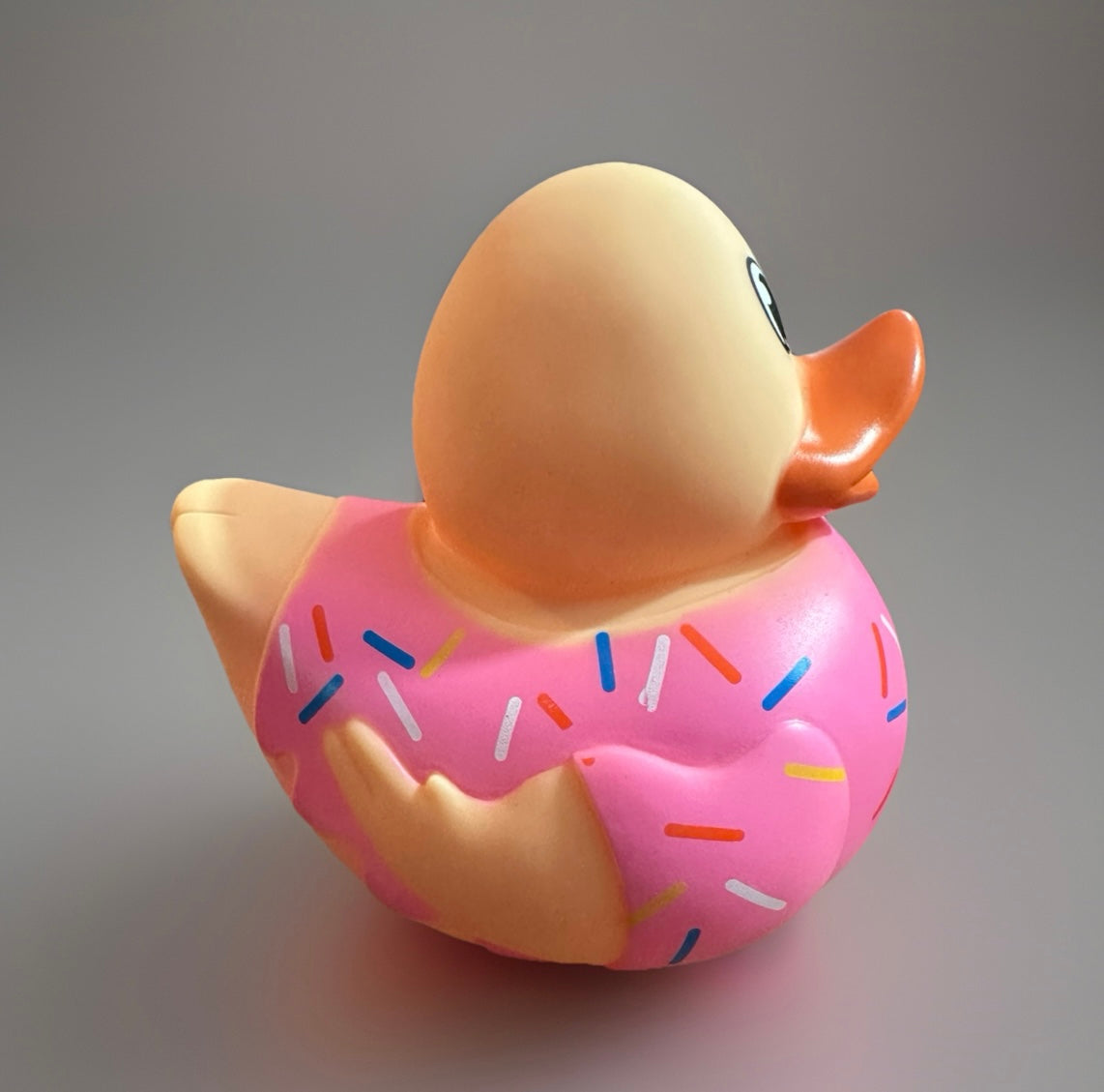 Donut rubber duck with pink frosting and colorful sprinkles  