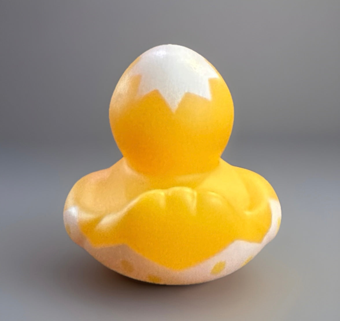 Yellow Easter egg rubber duck with white cracked eggshell design on the head and body