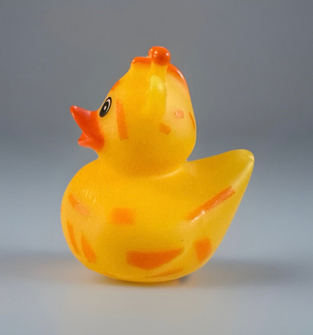 Giraffe rubber duck toy with yellow body and orange spots, designed by Reed’s Rubber Ducks and Sensory Shop