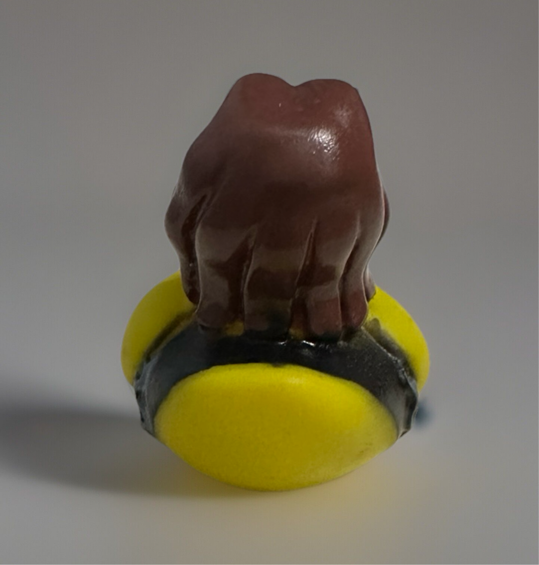 Back view of rock and roll rubber duck with brown hair and yellow outfit from Reed’s Rubber Ducks and Sensory Shop
