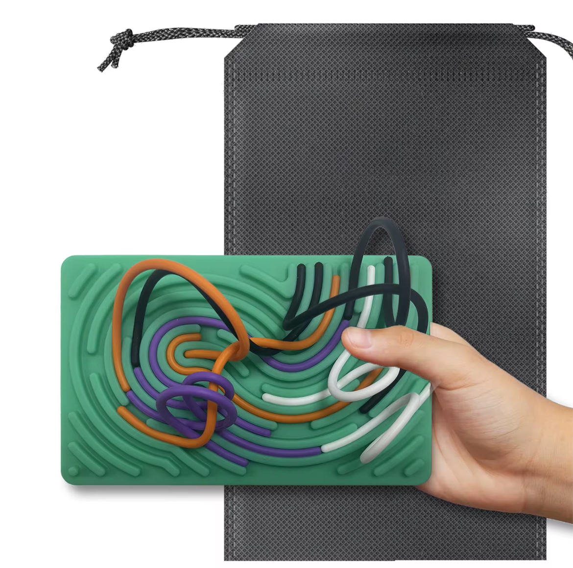 Hand holding green sensory activity mat with colorful raised patterns next to a gray drawstring storage bag