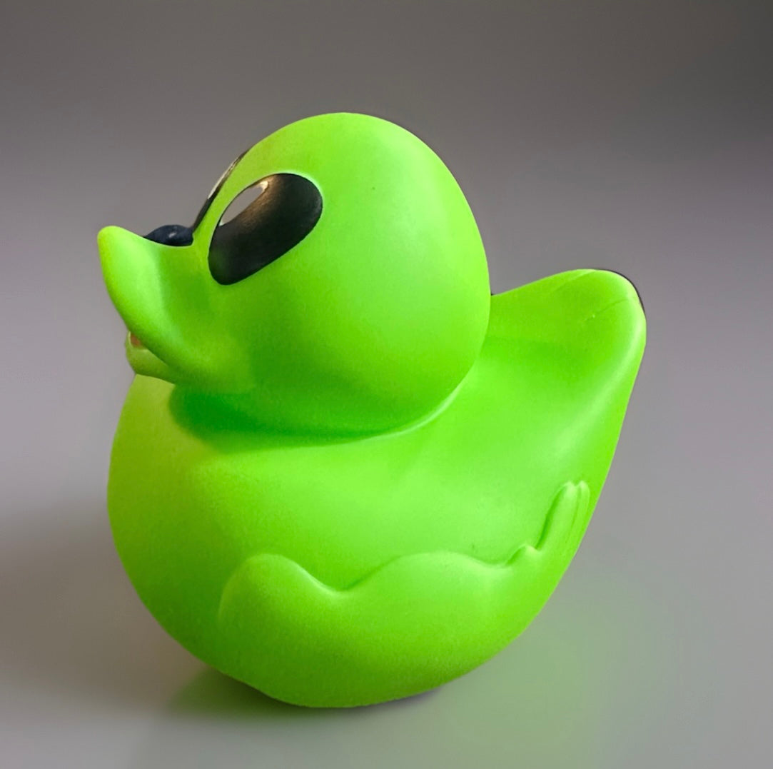 Neon green alien rubber duck with large black eyes 