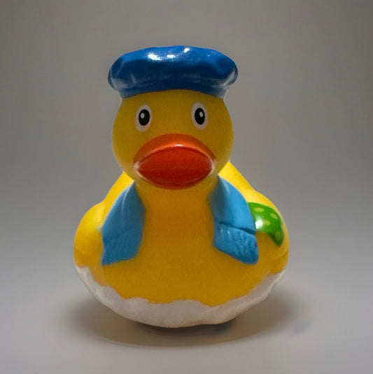 Yellow novelty rubber duck wearing blue hat and scarf with a green star design on back