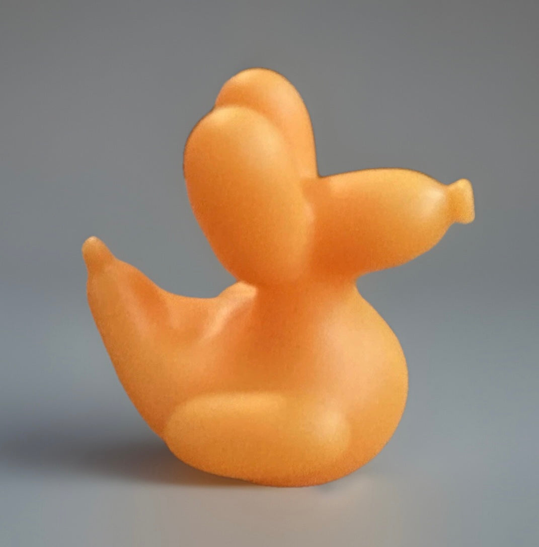 Orange balloon animal rubber duck from Reed’s Rubber Ducks and Sensory Shop on gray background