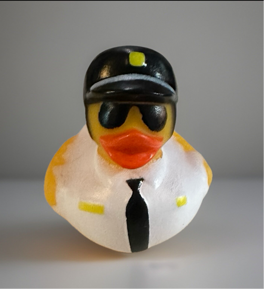 Police rubber duck wearing black police hat, sunglasses, white shirt, and black tie from Reed’s Rubber Ducks and Sensory Shop